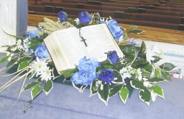 Casket spray with Dad's Bible and cross necklaces